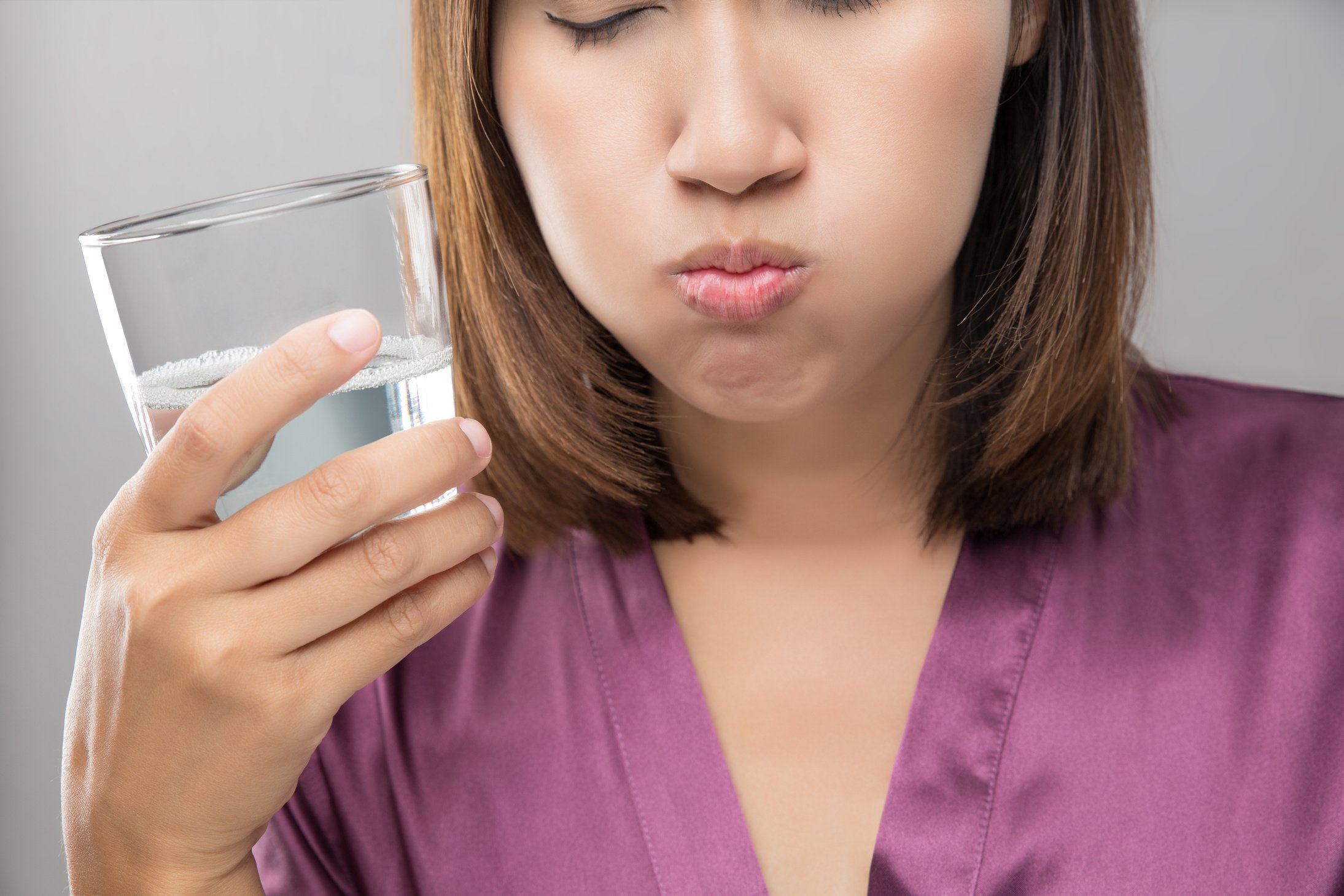 Woman rinsing and gargling while using mouthwash